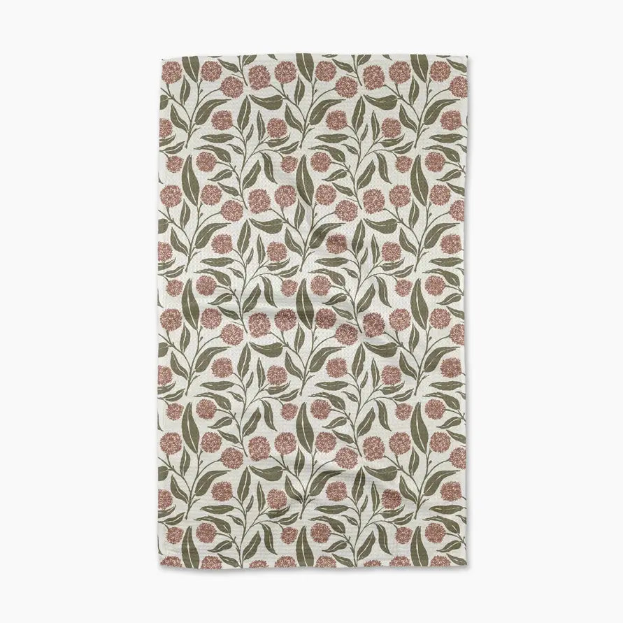 Floral patterned towel with pink flowers and green leaves on a white background