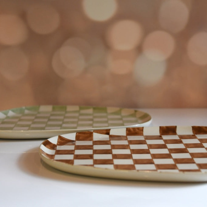 Two ceramic plates with checkered patterns on a blurred background