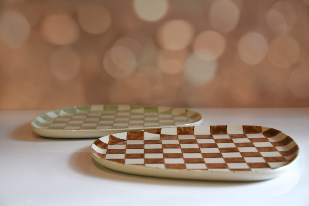 Two ceramic plates with checkered patterns on a blurred background