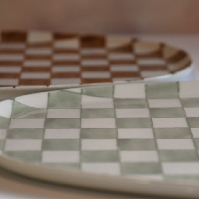 Two ceramic plates with checkered patterns on a blurred background