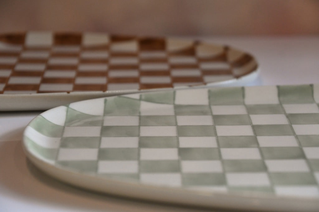 Two ceramic plates with checkered patterns on a blurred background