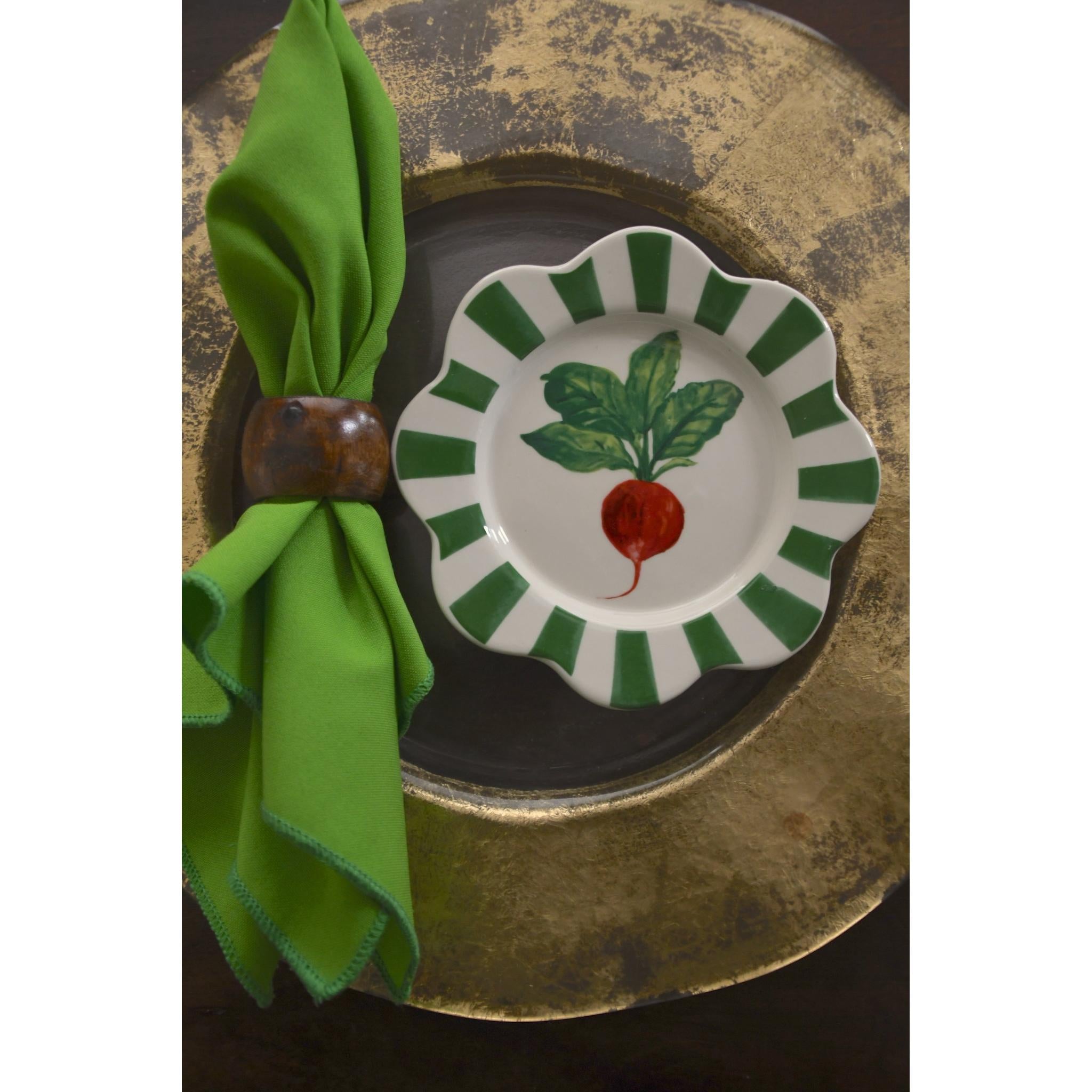 Decorative plate with a radish design on a green napkin against a gold and black background