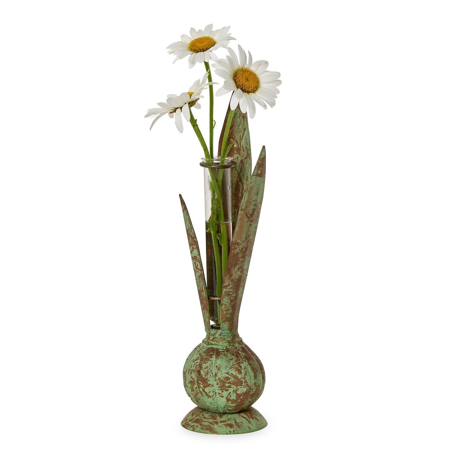 Decorative vase with a textured green finish holding three white daisies on a white background