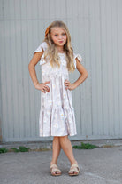 Childs dress with white flower print on a classic taupe dress. This dress is  feminine with flutter sleeves