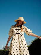 Polka dot babydolll with puff sleeves and bow front closure. 