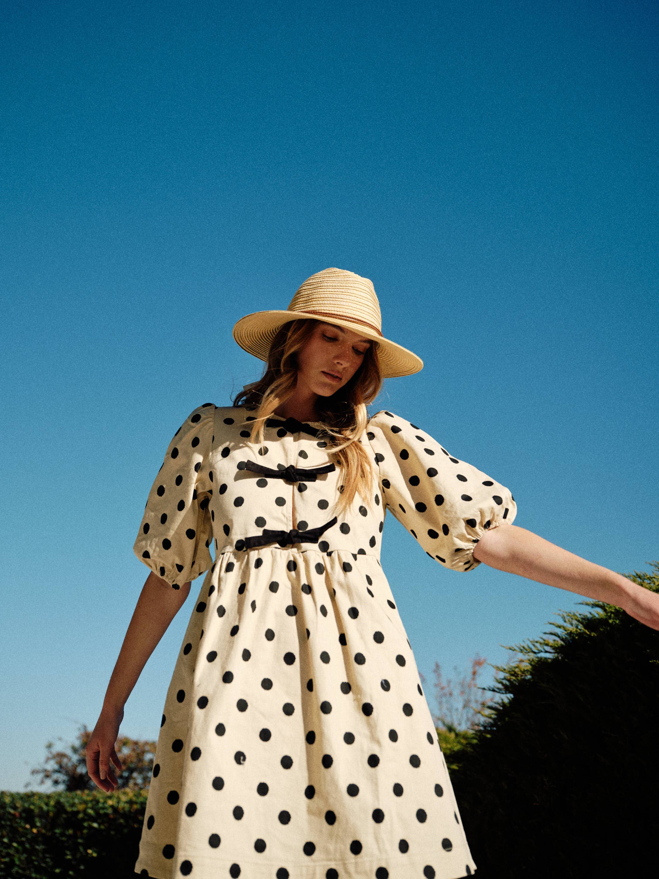 Polka dot babydolll with puff sleeves and bow front closure. 