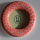 Ceramic frame with geometric pattern and 'HM' logo on a gray background