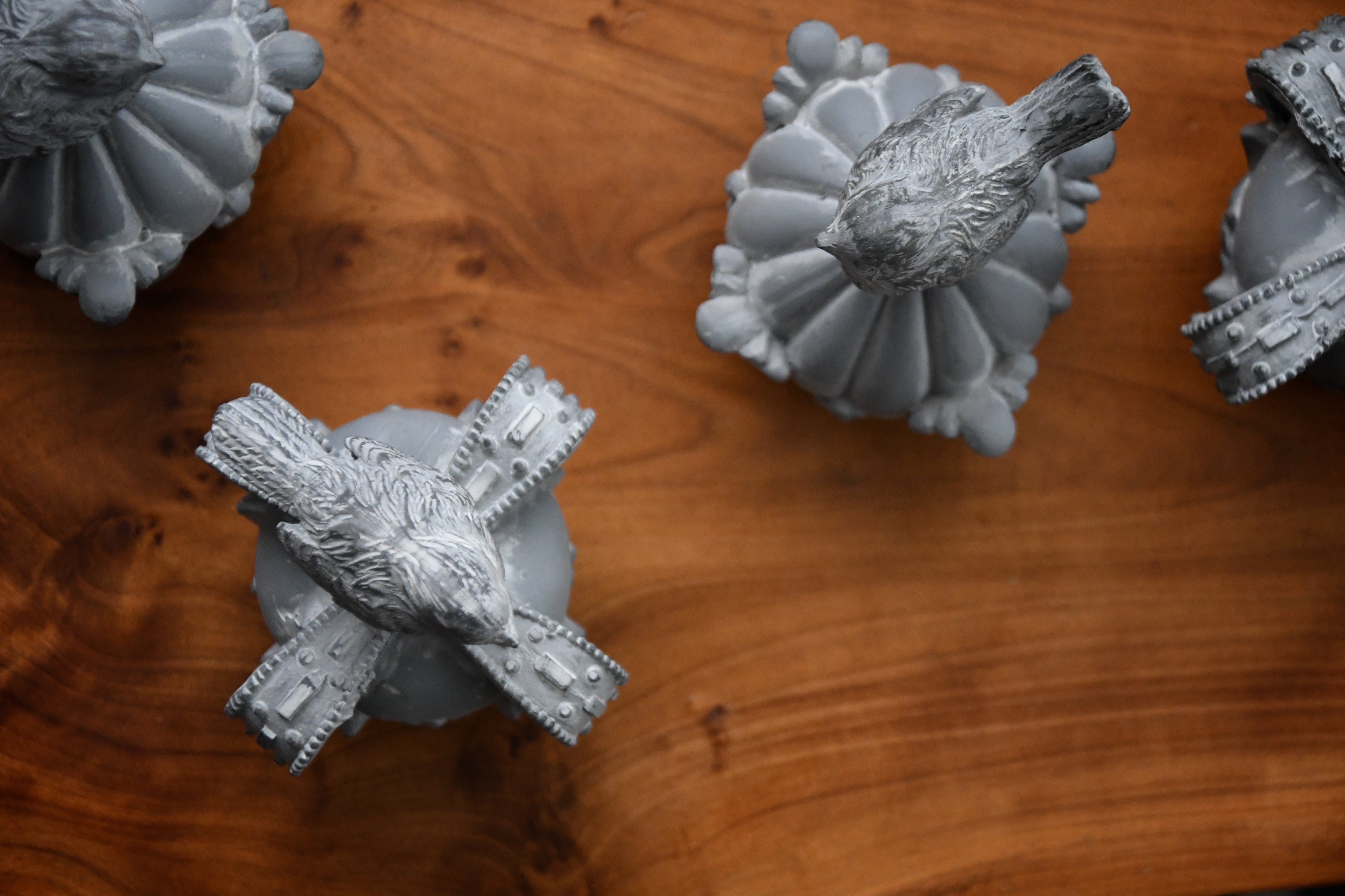 Gray stone carvings of birds on a wooden surface