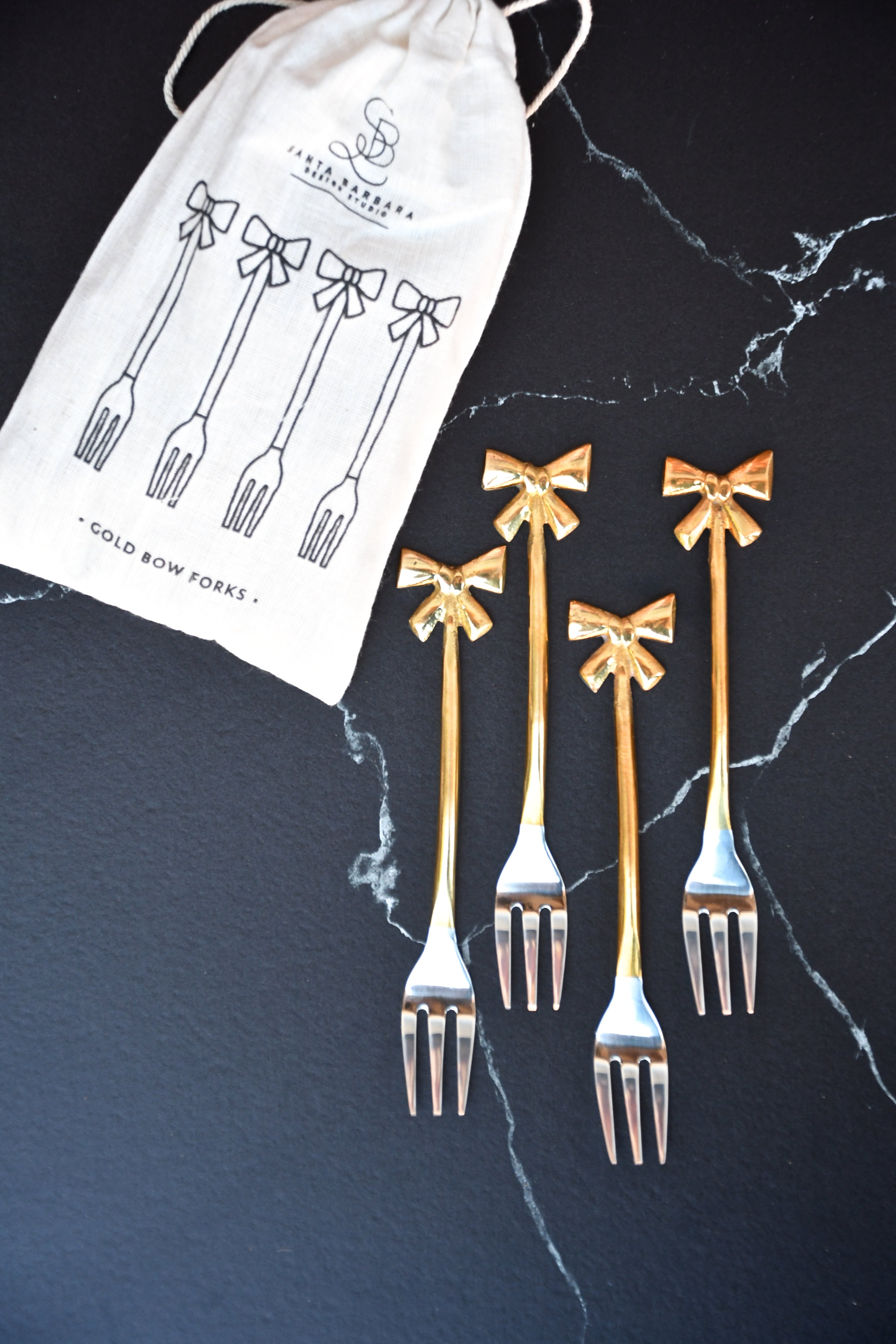set of 4 small forks with gold bows on handle.