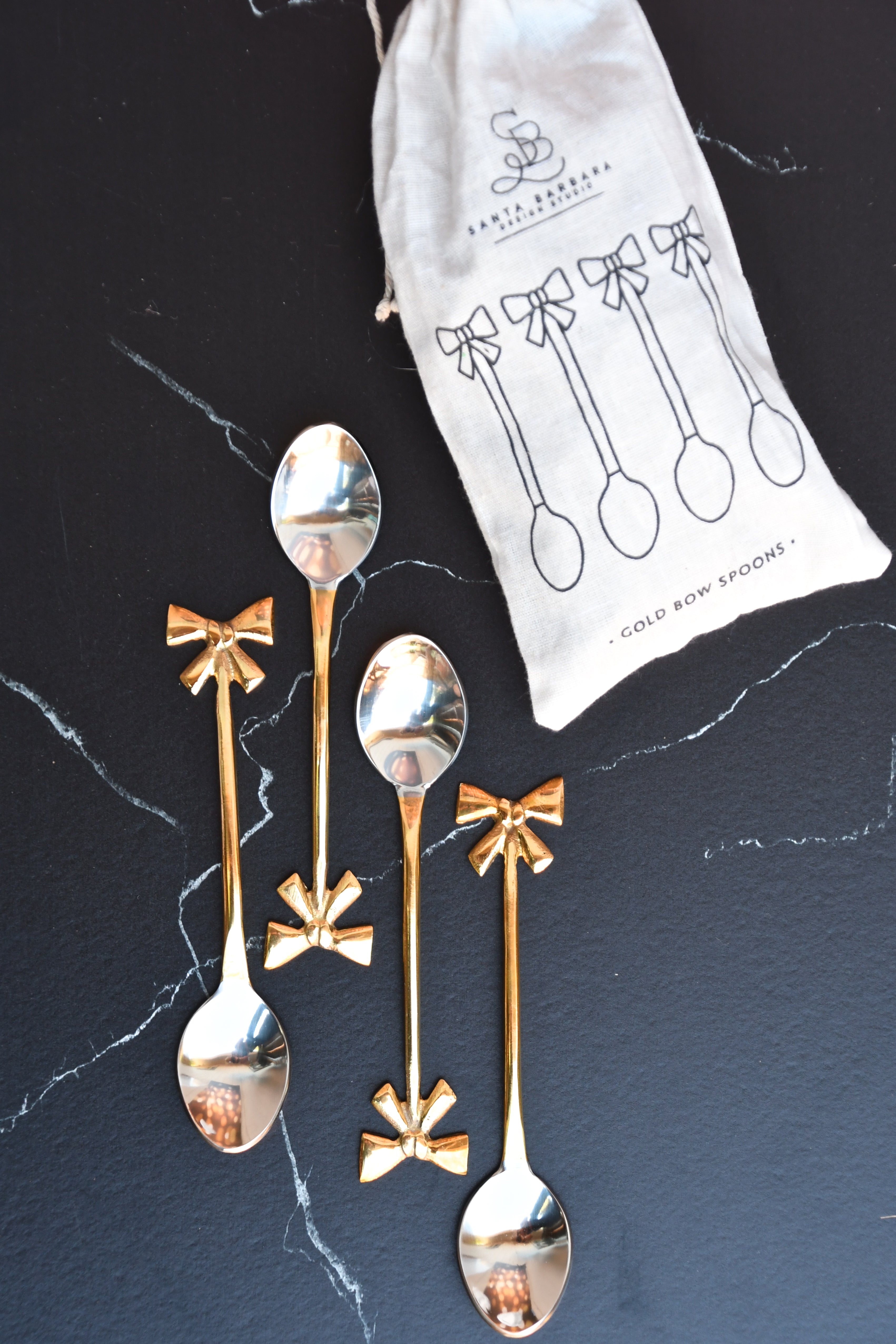 set of 4 gold bow spoons. Gold bow handle.