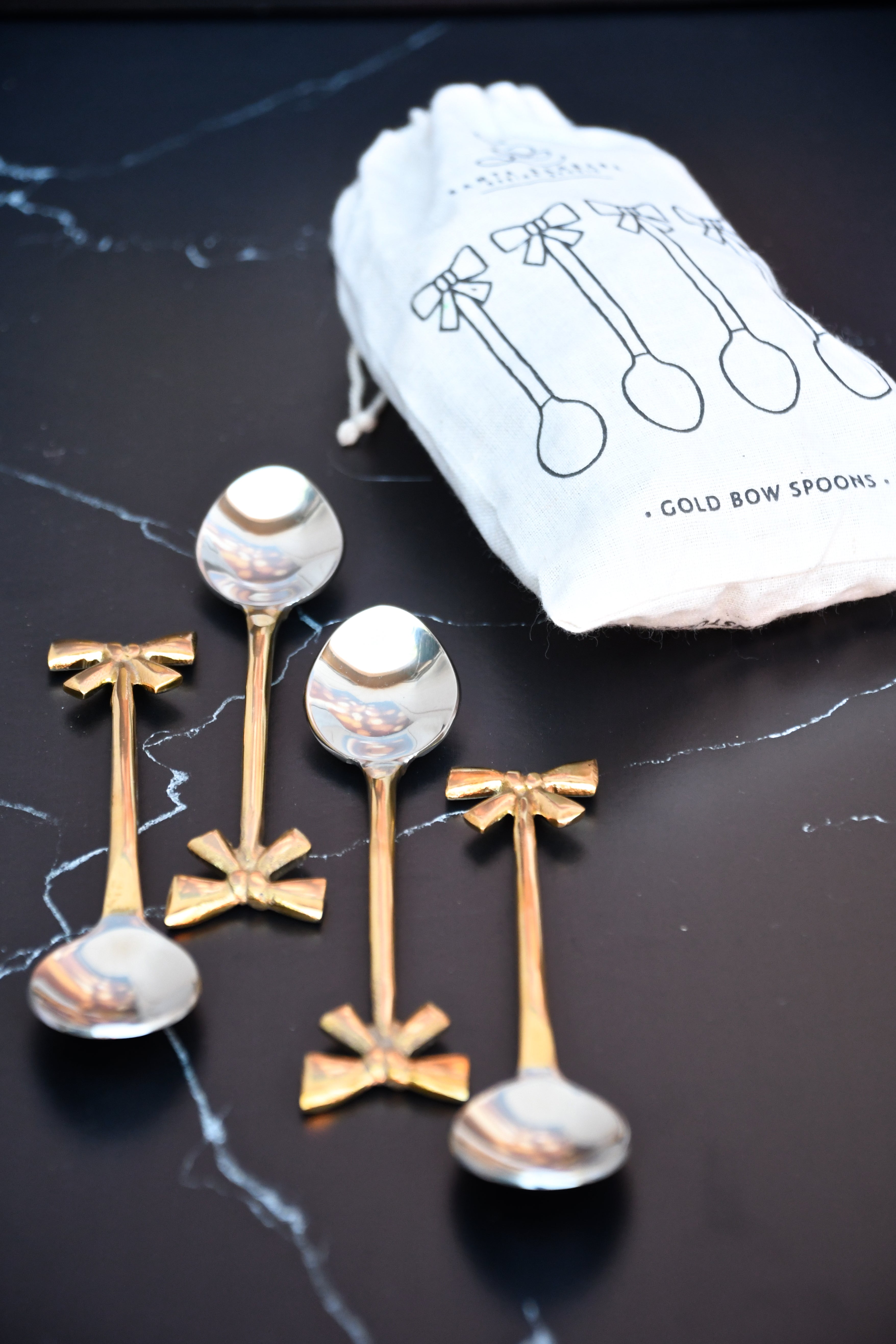 set of 4 gold bow spoons. Gold bow handle.