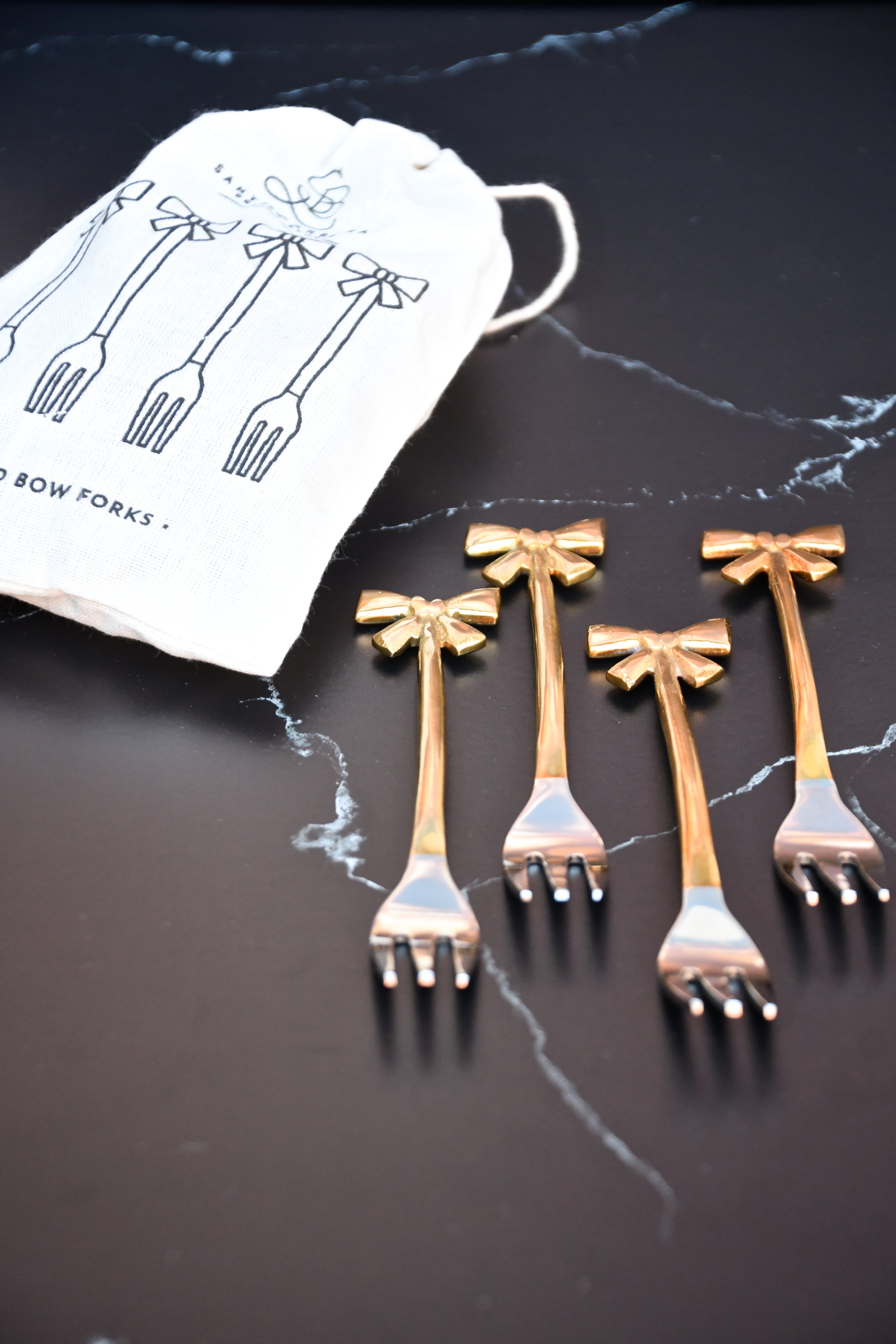 set of 4 small forks with gold bows on handle.