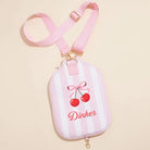 Small pouch with cherry design and 'Dinker' text on a beige background