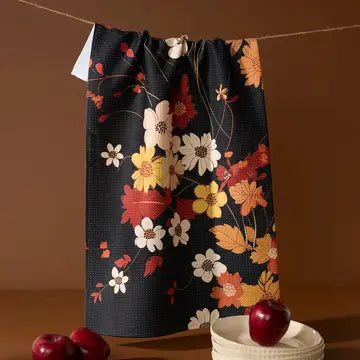 Floral-patterned bag hanging on a line with apples and a bowl below.