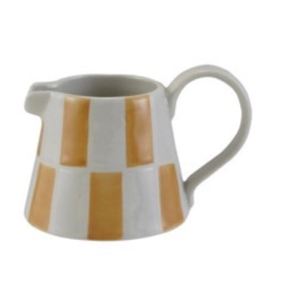 Ceramic pitcher with gold and white striped design on a white background