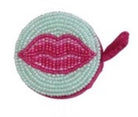 Circular object with beaded design and pink lips on a white background