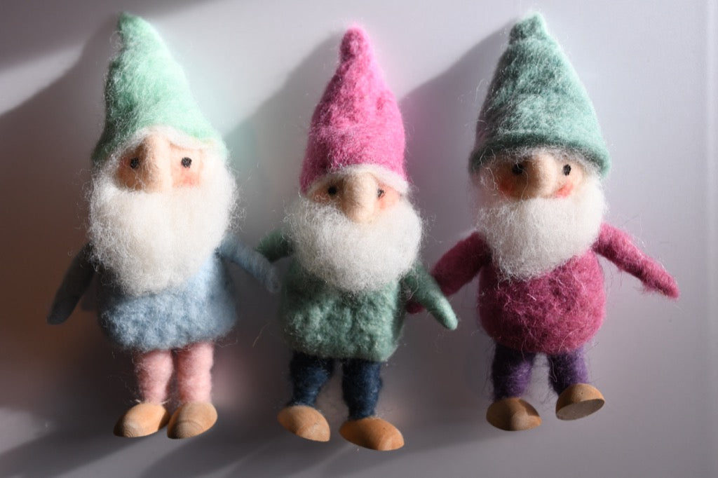 Three gnome figurines with colorful hats on a white background