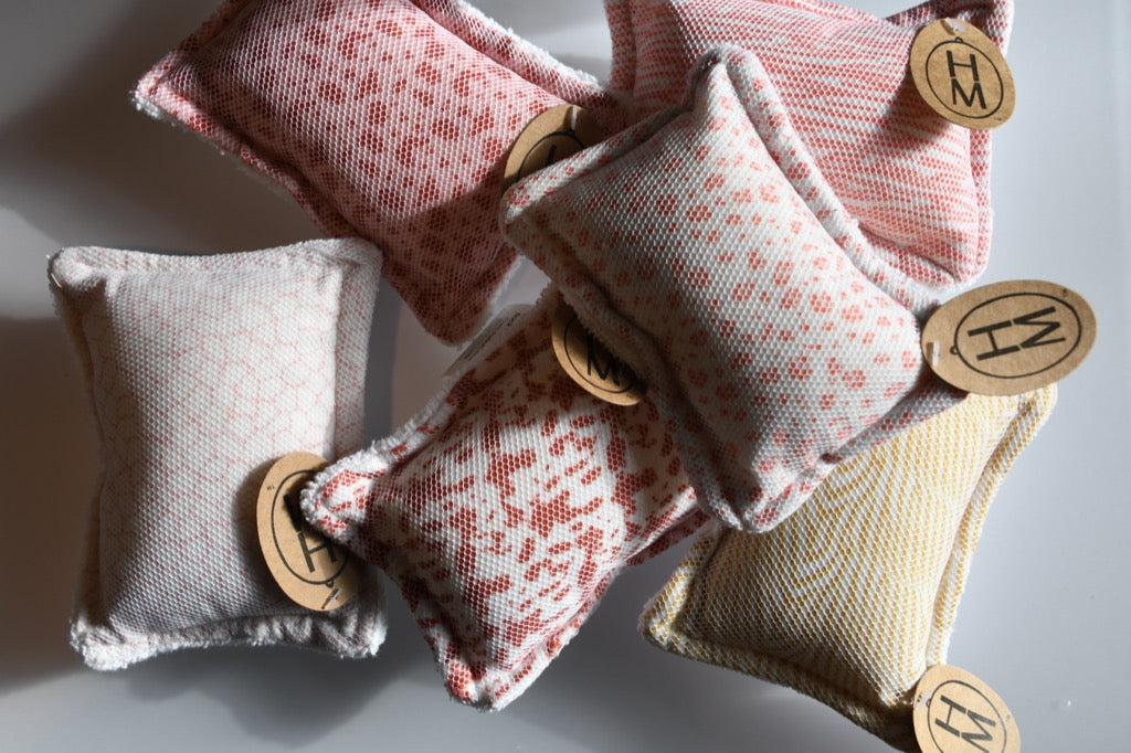 Small fabric sponges with wooden buttons on a light background