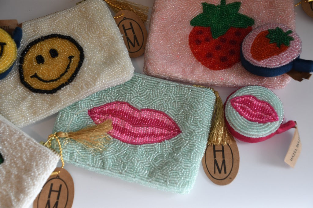 Collection of embroidered pouches with visible brand 'HM' on a white background