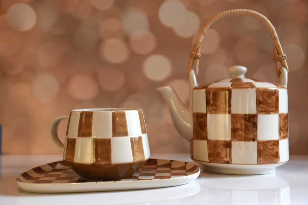Ceramic tea set with checkered pattern on a blurred background