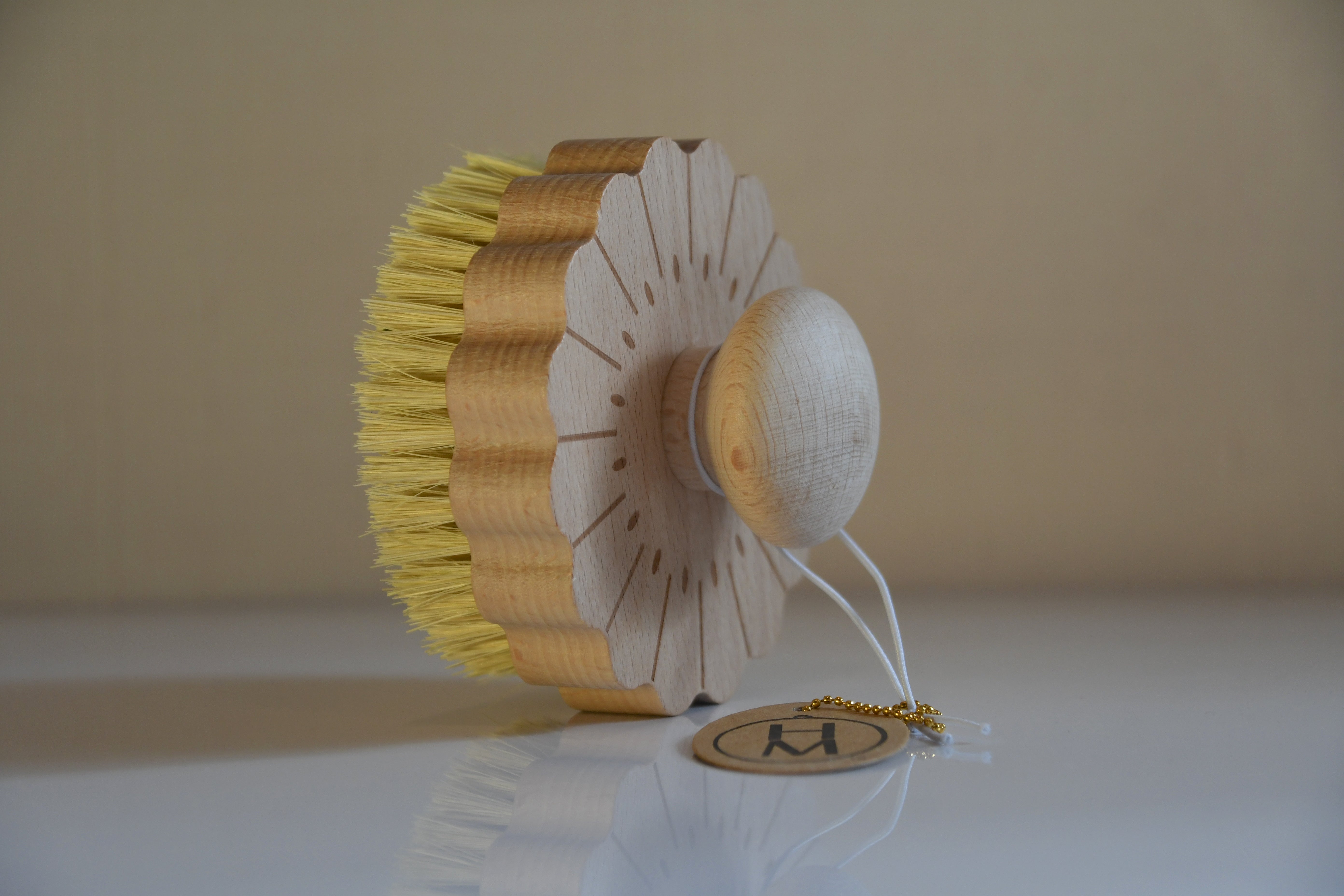 Decorative item with yellow bristles and white base on a beige background