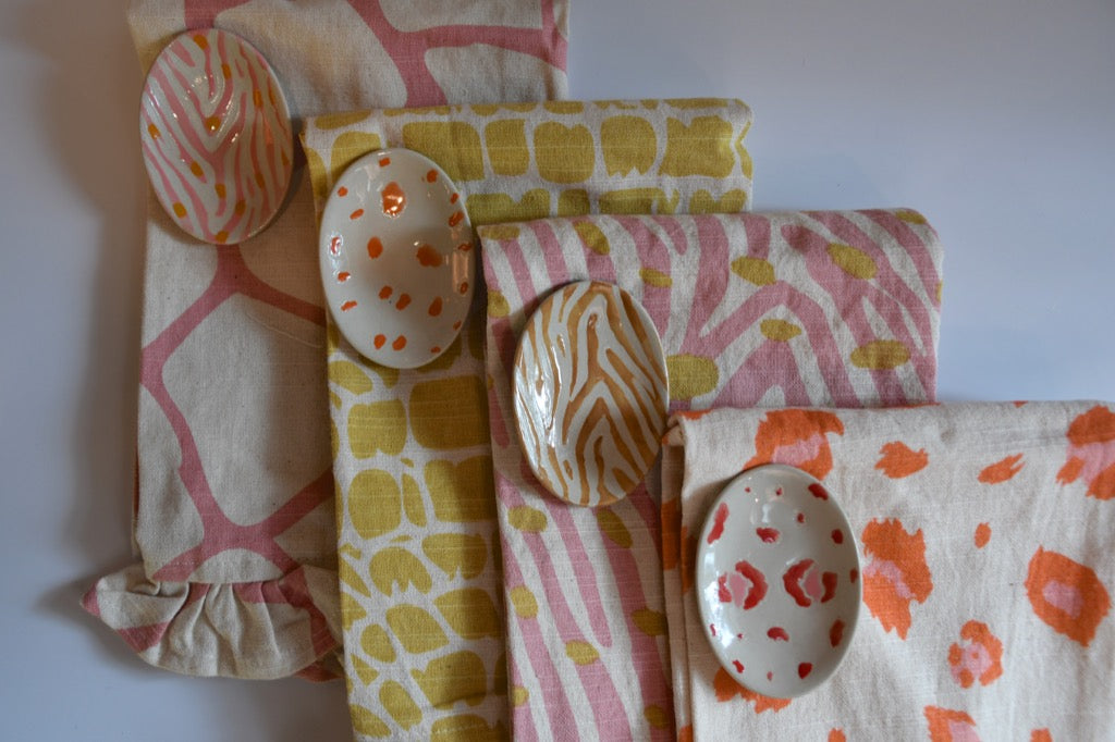 Patterned cloths and ceramic spoons on a white surface