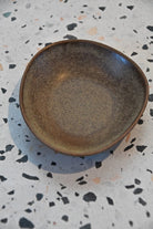 Brown ceramic plate on a speckled countertop