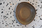 Brown ceramic plate on a speckled gray surface