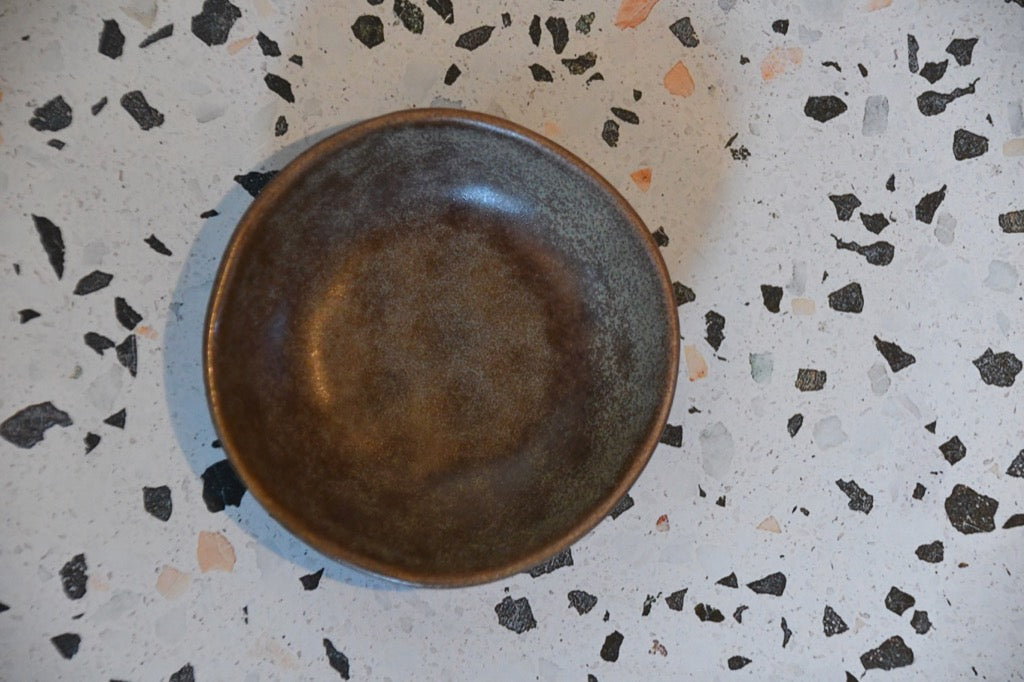 Brown ceramic bowl on a terrazzo countertop