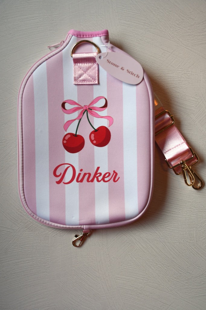 Pink and white striped pouch with cherry design and 'Dinker' text on a light gray background