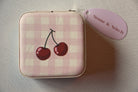 Small pink checkered pouch with cherry design on a light surface, featuring a 'Stone & Stitch' tag.