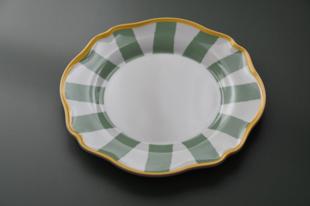 Decorative plate with green and gold rim on a dark background