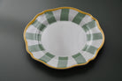 Decorative plate with green and gold rim on a dark background