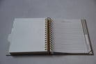Open notebook with lined pages on a gray surface