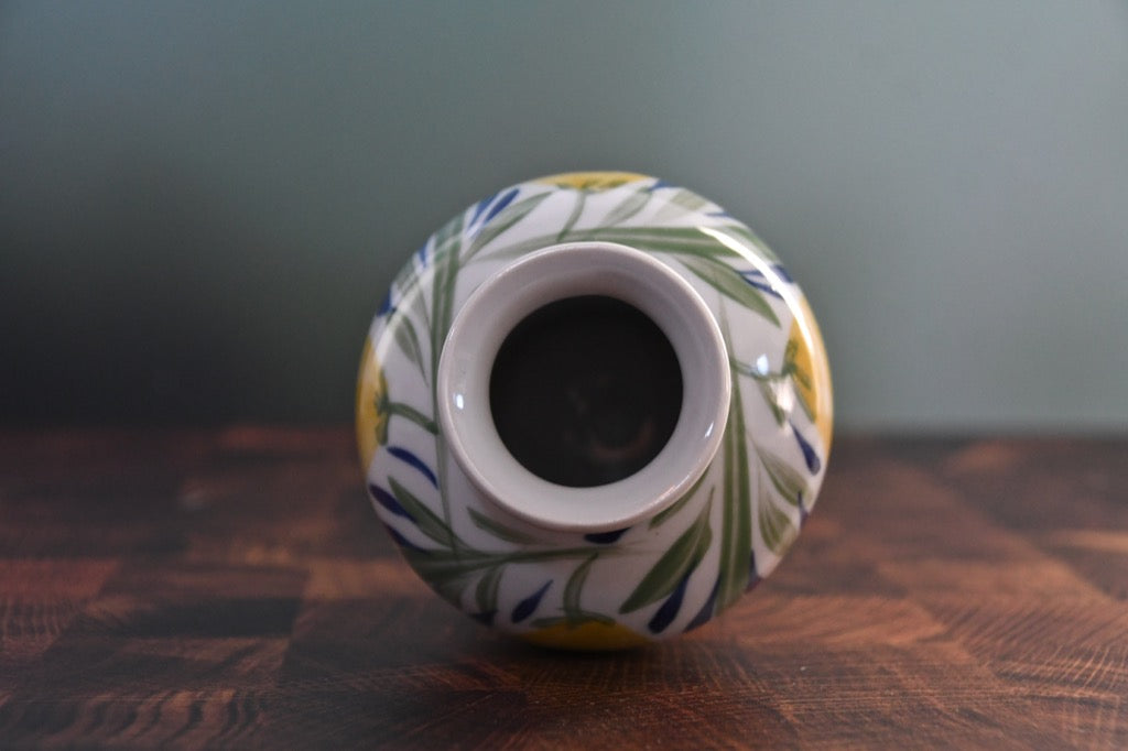 Decorative ceramic vase with floral patterns on a wooden surface