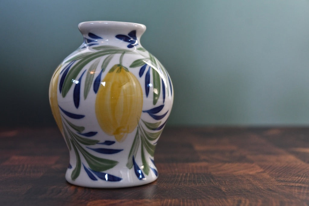 Decorative ceramic vase with lemon design on a wooden surface