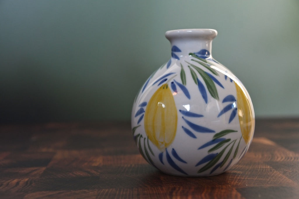 Ceramic vase with floral design on a wooden surface