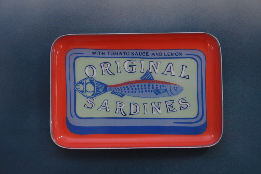 Vintage-style metal tray with 'Original Sardines' label on a dark background