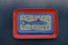 Vintage-style metal tray with 'Original Sardines' label on a dark background