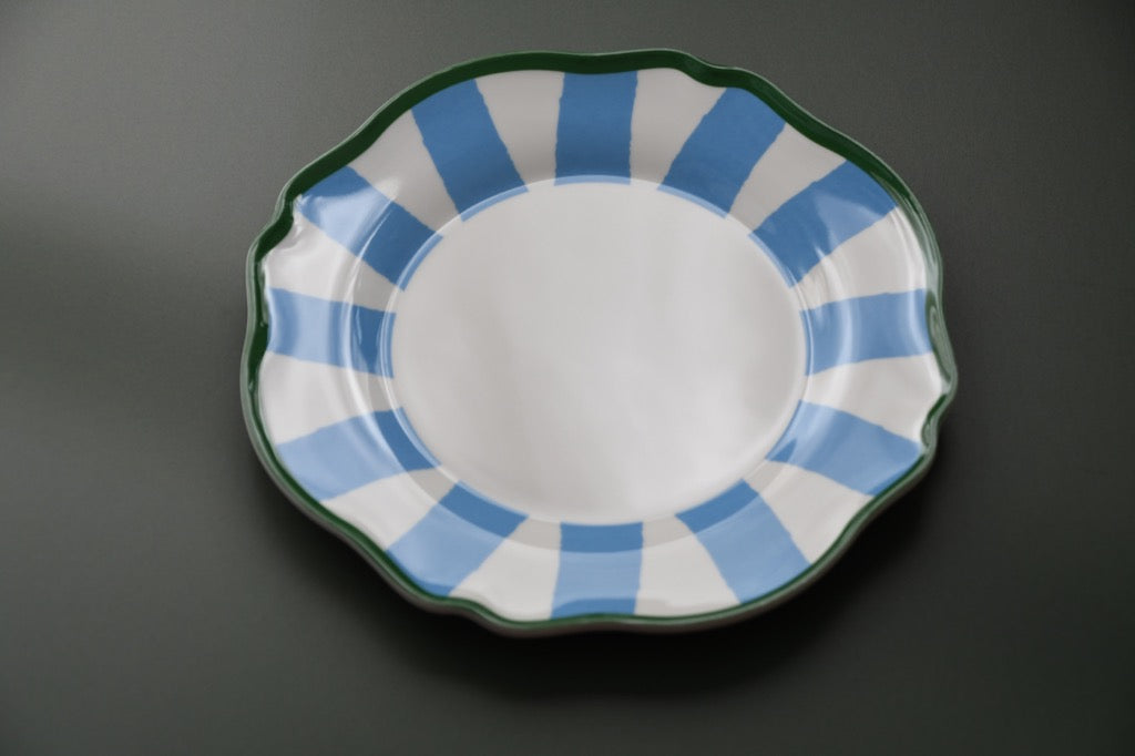 Plastic plate with blue and white striped rim on a dark background