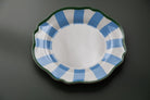 Plastic plate with blue and white striped rim on a dark background