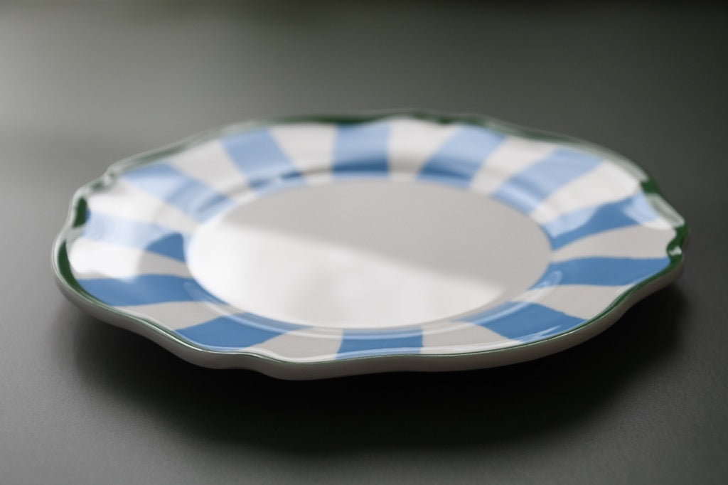 plastic plate with blue and white striped rim on a dark background
