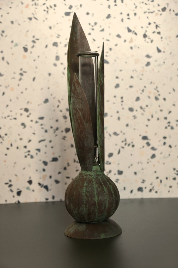 Bronze sculpture with a textured surface on a speckled background