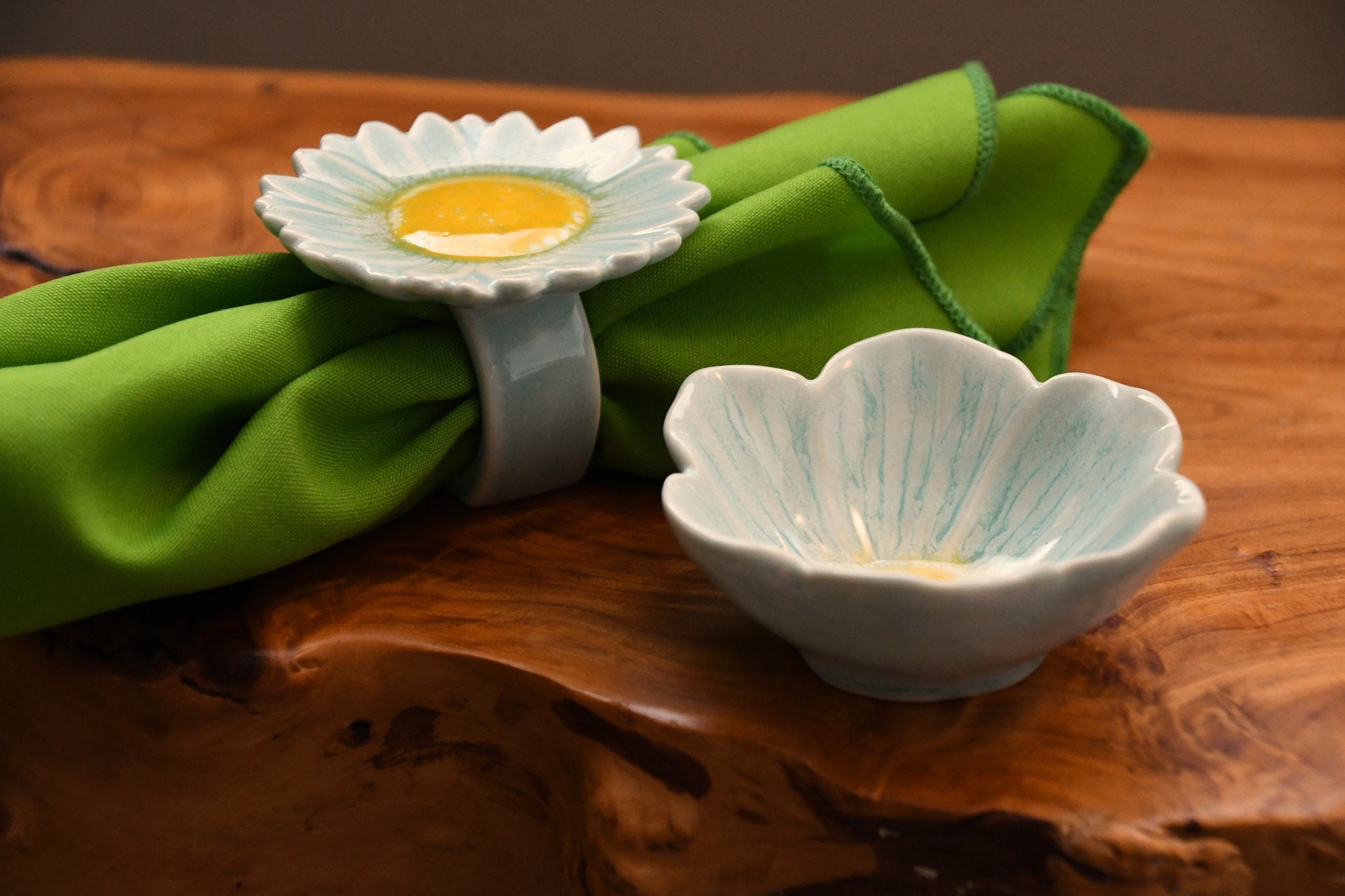 Decorative ceramic items on a wooden surface with green fabric
