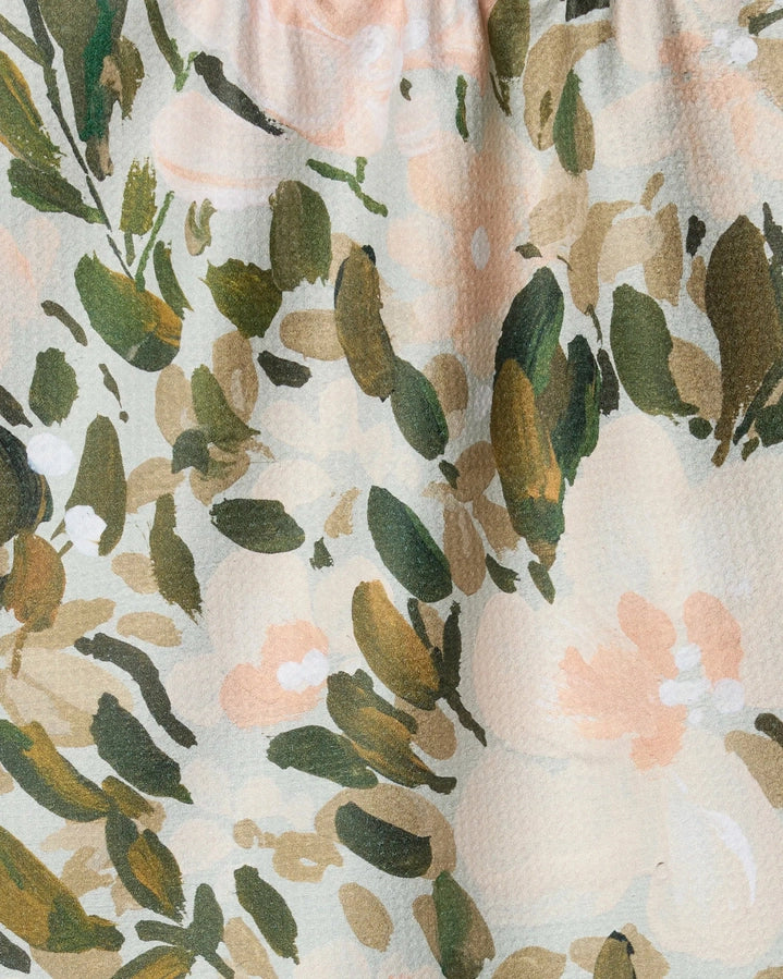 Floral patterned fabric with green leaves and pink flowers on a beige background