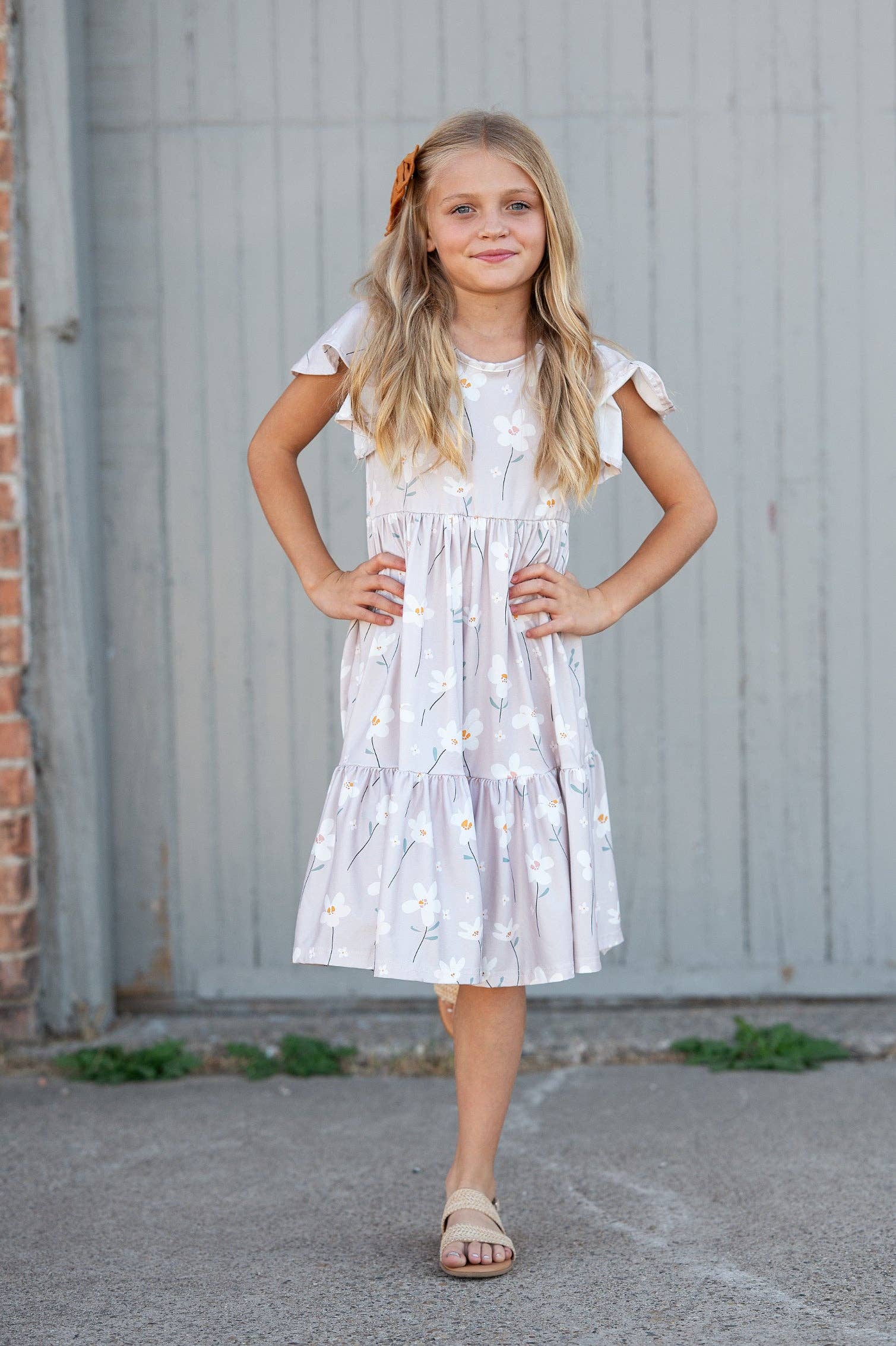 Childs dress with white flower print on a classic taupe dress. This dress is  feminine with flutter sleeves