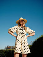 Polka dot babydolll with puff sleeves and bow front closure. 