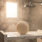 Bar of soap on a marble surface with a blurred bathroom background