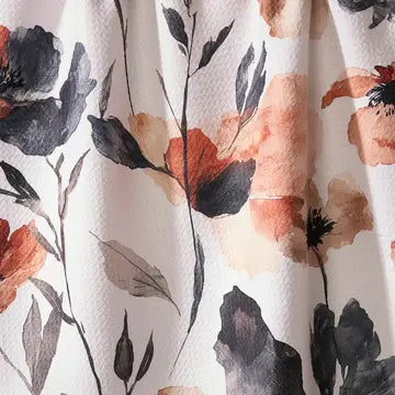 A close-up of a textured fabric with a watercolor floral print featuring dark gray, burnt orange, and beige flowers on a white background.
