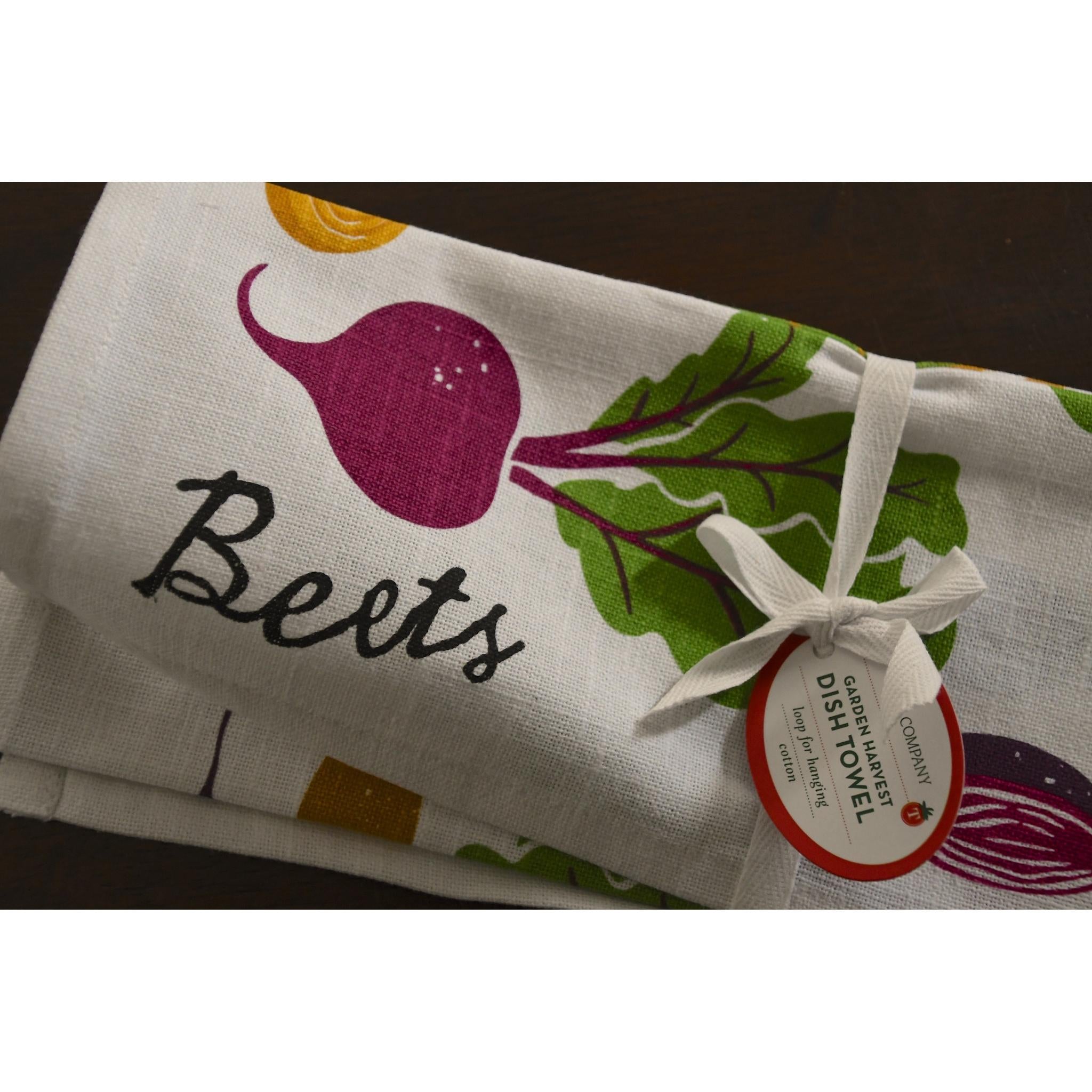 Folded dish towel with beets design and 'Beets' text, tied with a ribbon, on a white background.